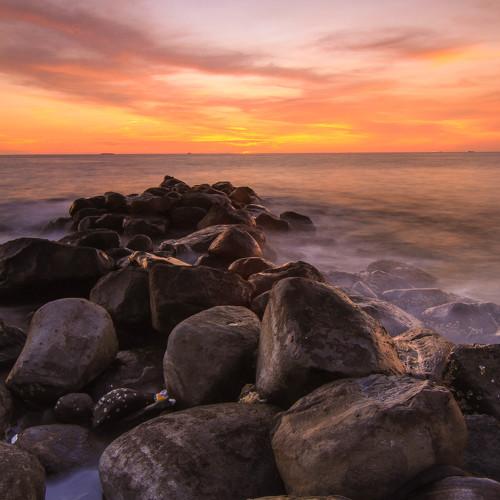 Tepian pantai berbatu di sore hari