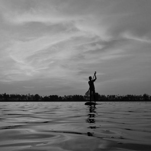 The stand up paddleboarding boy