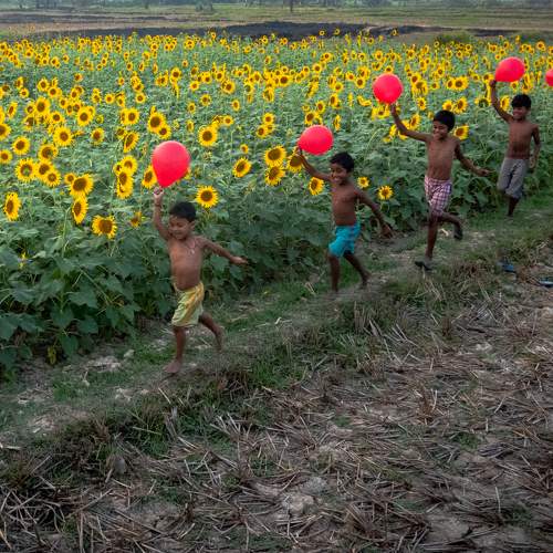 Happy Kids Running Together With Balloons