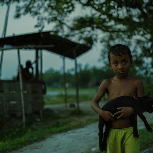 Poor boy playing with goat