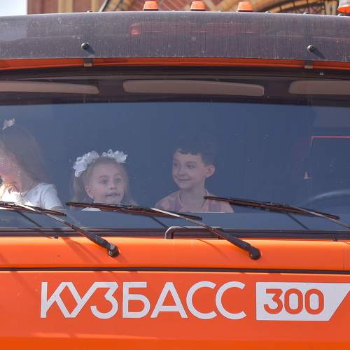 Первоклассники сидят в кабине КАМАЗа.