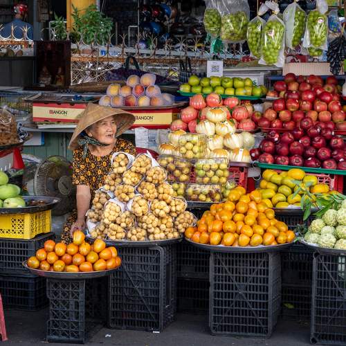 A Vietnamese woman by a fruit shop