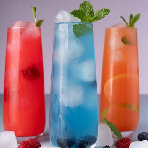 summer beverages with red, blue, and orange hues, garnished with mint leaves