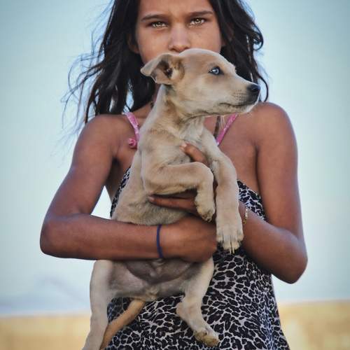 Niña y su cachorro en un pueblito de Macanao