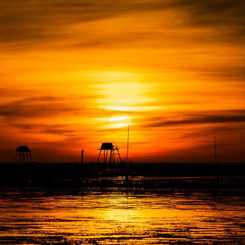 The sun dips below the horizon, bathing the sky in a spectacular wash of orange and gold