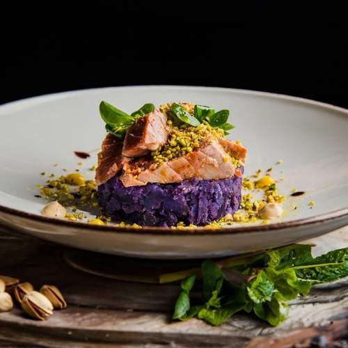 Red tuna on purple potato flatbread and chopped pistachios.