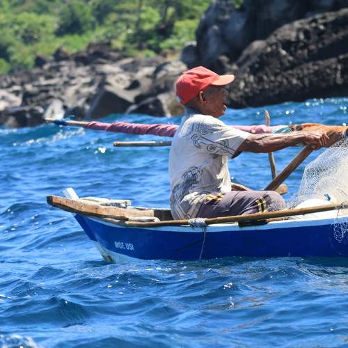 A fisherman on wooden boat