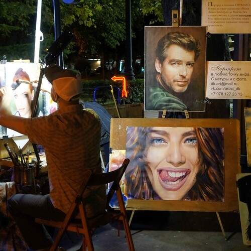 Уличный художник, работающий над портретом