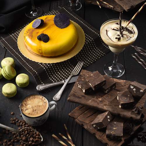 Luxury dessert table with brownies, macarons and coffee on rustic background