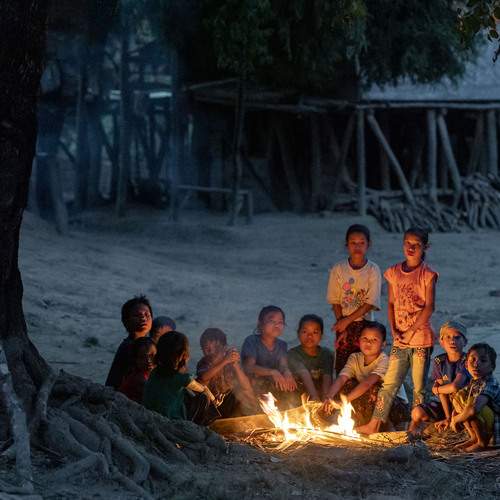 Mro children of the Chittagong Hill Tracts gather around a campfire, sharing stories and finding light in the embrace of the night.