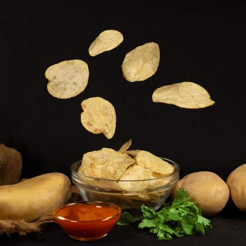 Levitation of crispy potato chips above a bowl, creating a magical floating snack moment.