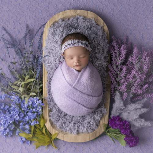 Newborn girl with purple flowers