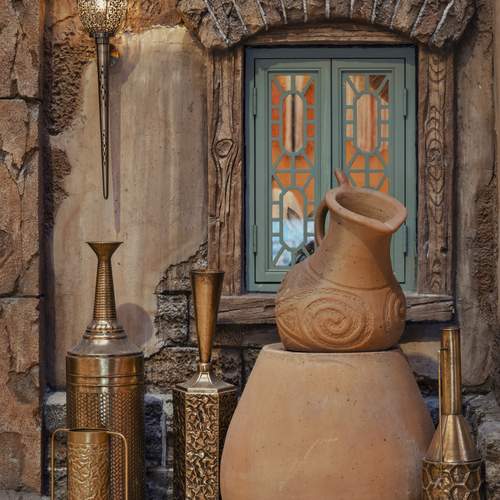 Beautifully crafted clay pots are positioned in front of a window