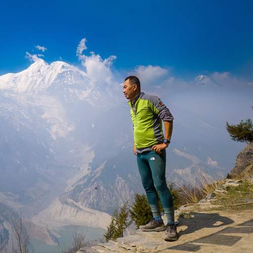 the person is trekking or hiking along a mountain trail.