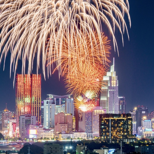 Orange Fireworks Reflecting on City Skyscraper at Night