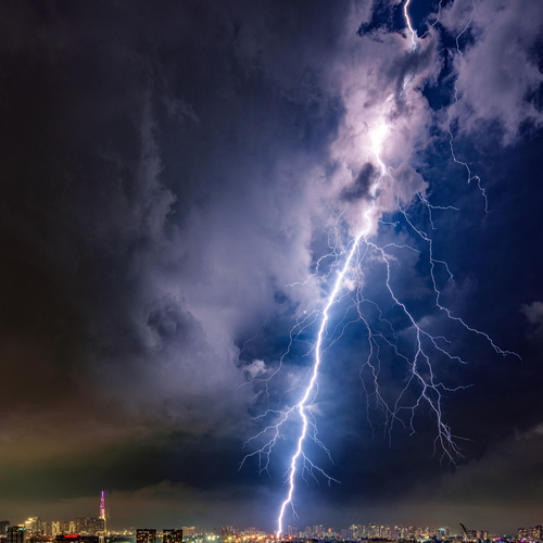 Dramatic Lightning Strike Over City Skyline at Night