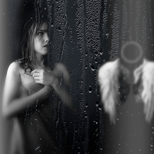 A beautiful detailed close up black and white portrait photograph showing a sad woman behind wet window glass next to abstract blurred angel wings