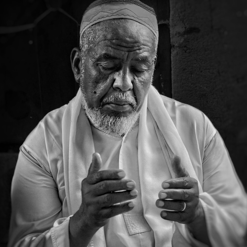 Black and White Portrait of Sudanese Man in Traditional Islamic Prayer