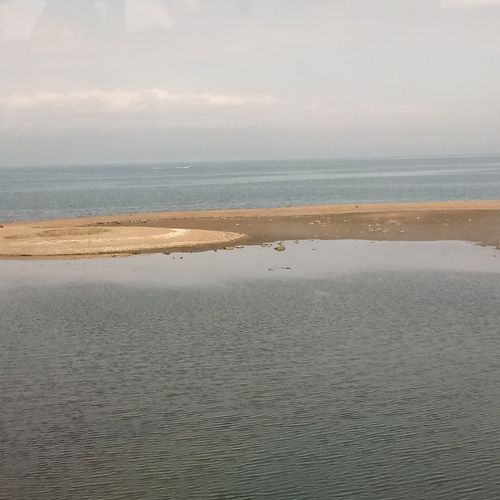 Полоска пляжа среди воды.