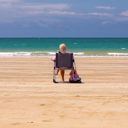 Woman Relaxing on Sandy Beach Facing the Atlantic Ocean in Cadiz, Spain