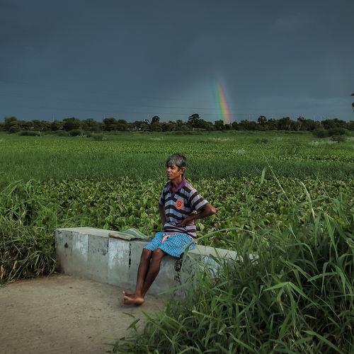 Rainbow behind rural man