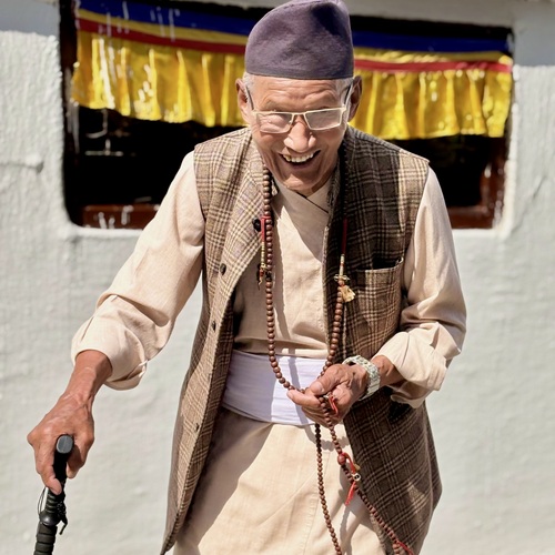 Spiritual joy - Elderly Tibetan Buddhist man laughing at a monastery in Nepal