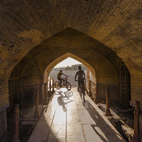 Cyclists passing under the arch of old boys