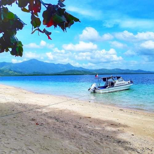 A yatch, a sand and a blue sea water