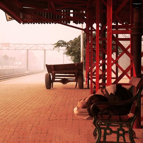 A Homeless begger laying on station bench