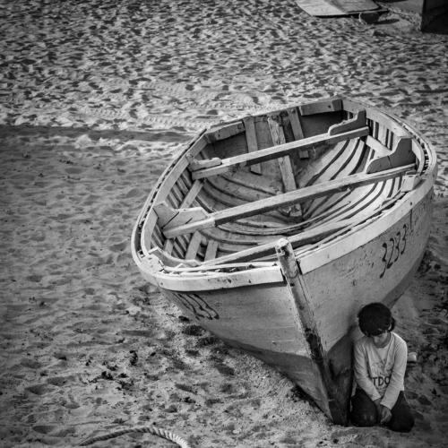 HIidden in the shadow of the boat
