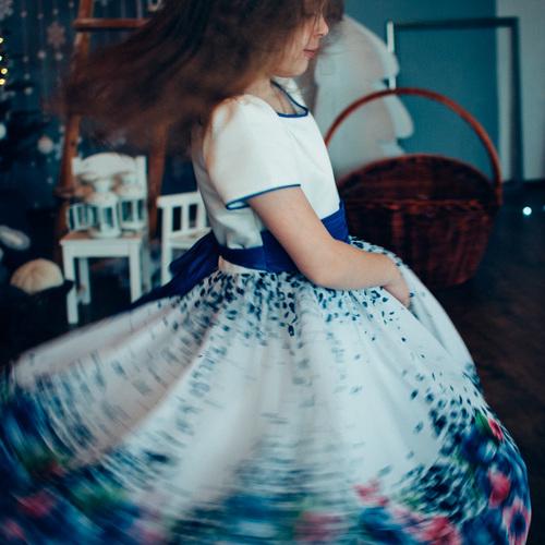 The girl whirls near the Christmas tree