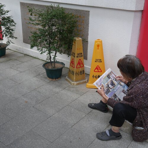 A senior citizen reading her newspapers