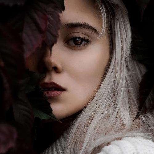 Mysterious girl in the leaves of wild grapes