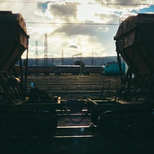 Trains standing face to face at sunset.
