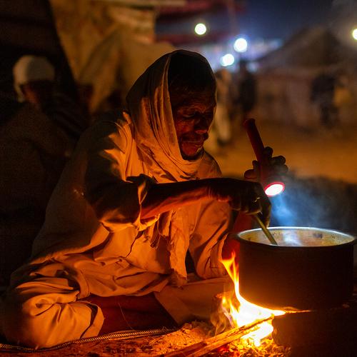 A camel shepherd is preparing food under the sky in Pushkar Fair
