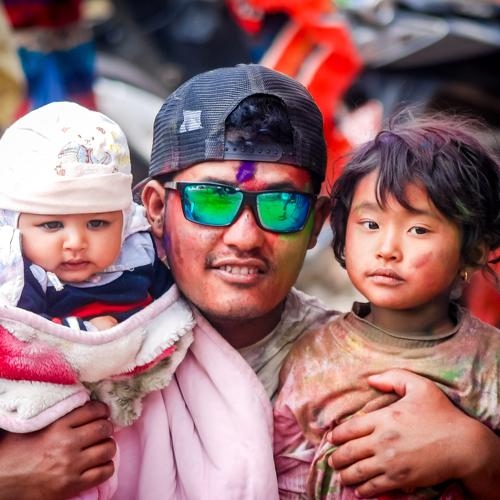 A father and his kids celebrating Holi festival