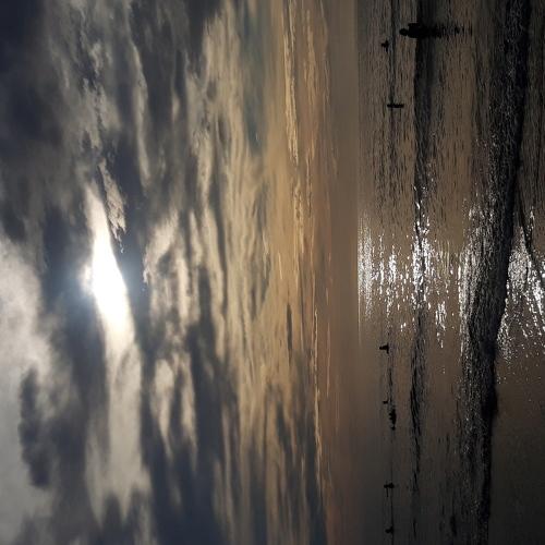 The Sun's light peeping behind the clouds.
