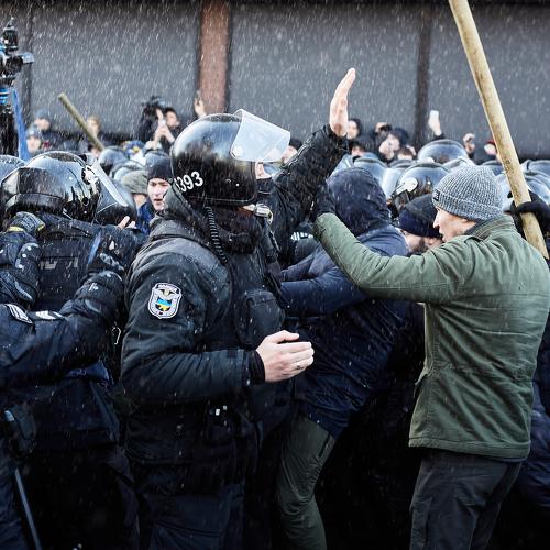 The policeman calls the protesters to calm down.