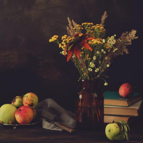 Still life with wild flowers and apples.